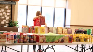 Thanks for Giving volunteer sorting donated grocery items